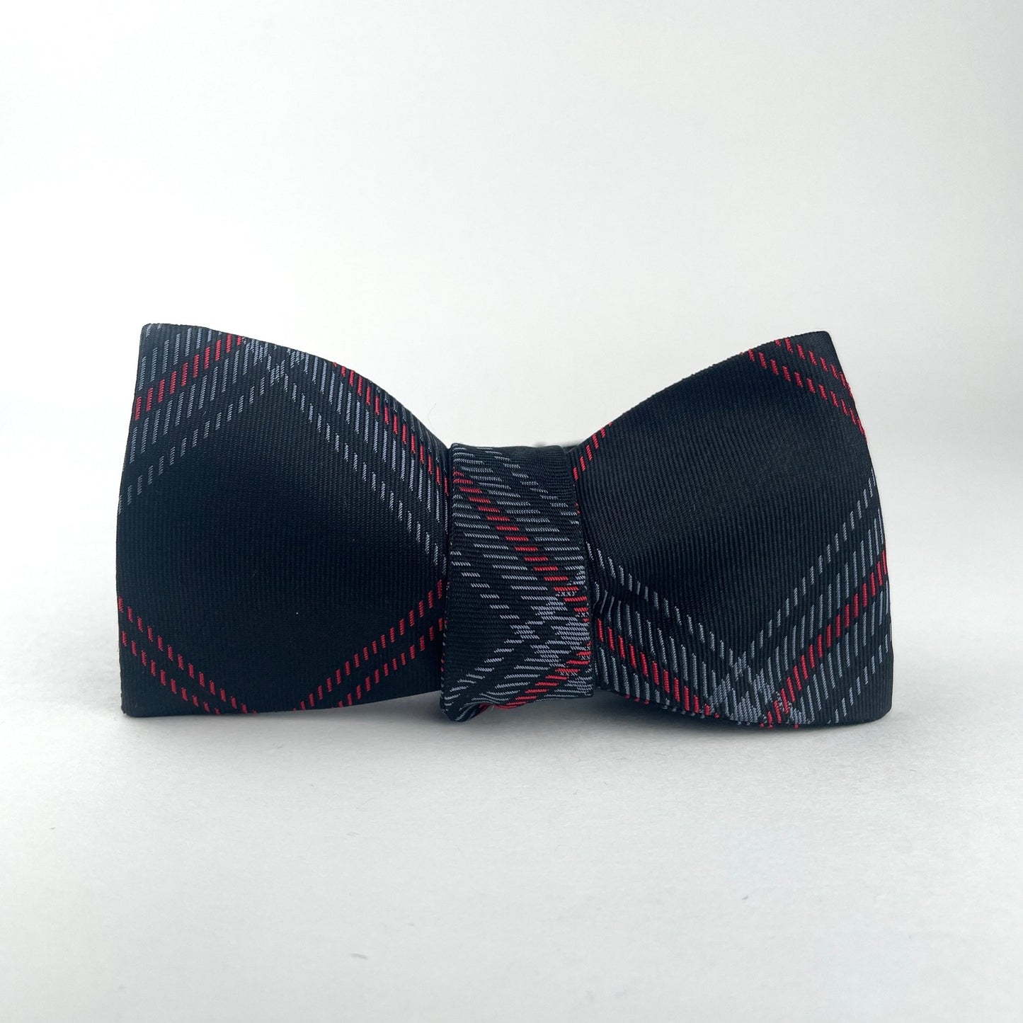 Black silk tie with grey and red plaid maid in America